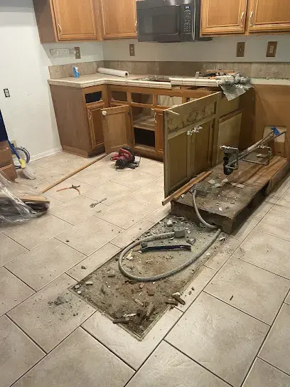 Kitchen flooring pulled up to the bare concrete so the slab can dry