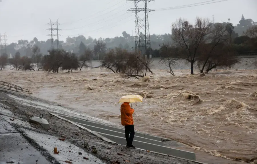 A wash swollen by a winter storm and running high beneath power lines in the Colton area