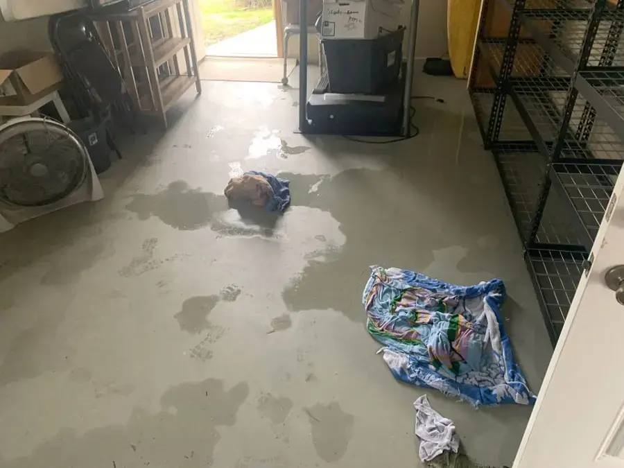 Water spread across a garage floor after a water heater leak in Highland